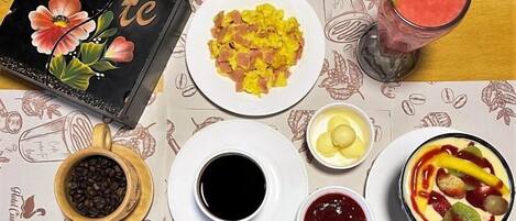 Una mesa de desayuno con café, huevos revueltos, tostadas y una ensalada de frutas.