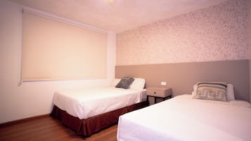 Un dormitorio con dos camas, una ventana con persiana, una mesita de noche y una pared con diseño texturizado.