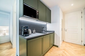 A modern kitchen with a built-in microwave, coffee maker, and kettle.