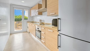 A modern kitchen with a built-in oven, a microwave, and a stainless steel refrigerator. - Holiday Apartment "Amanda" with Mountain View, Shared Pool & Wi-Fi (Xàbia)