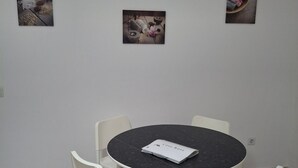 A room with a round table, four chairs, and two framed pictures on the wall. - Holiday Home "Casa Rosi" with Mountain Views and Wi-Fi (Gran Tarajal)