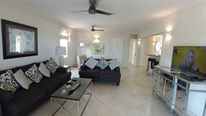 A living room with a sofa, coffee table, and TV stand.