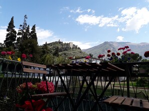 A view of a castle on a hill with a garden in the foreground. - Arco Apartments at Centro Stivo (Arco)