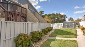 A residential property with a sloped roof, a wooden deck, and a white picket fence. - 2 Bedroom 2 Bath outdoor pool (Ocean City)