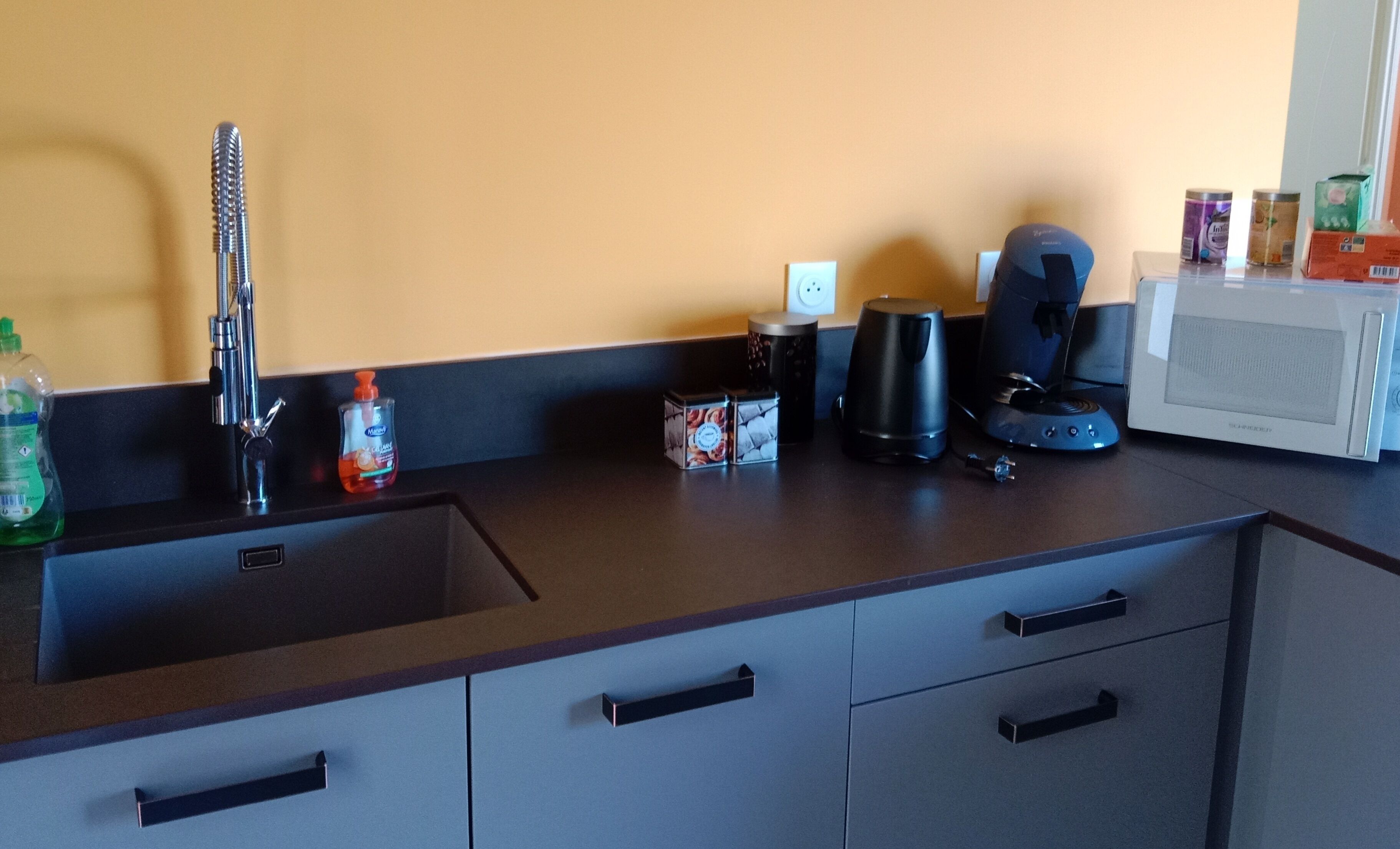 Cuina amb rentatalls, aixeta, cafetera i armaris.