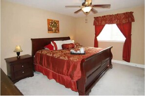 A bedroom with a bed, a nightstand, a lamp, a ceiling fan, and a window with curtains. - Enjoy Vacation in a Quiet Area w/ Huge Backyard! (Crosby)