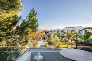 A resort with a pool, palm trees, and a view of the buildings. - Malena Hotel and Suites - Adults Only by Omilos Hotels (Malevizi)