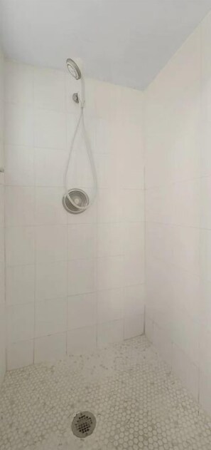 A shower with a handheld showerhead and a drain. - Beautiful, spacious one bedroom apartment. (Clearwater)