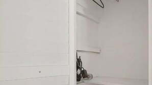 A white closet with sliding doors, a shoe rack, and a fire extinguisher. - Beautiful, spacious one bedroom apartment. (Clearwater)