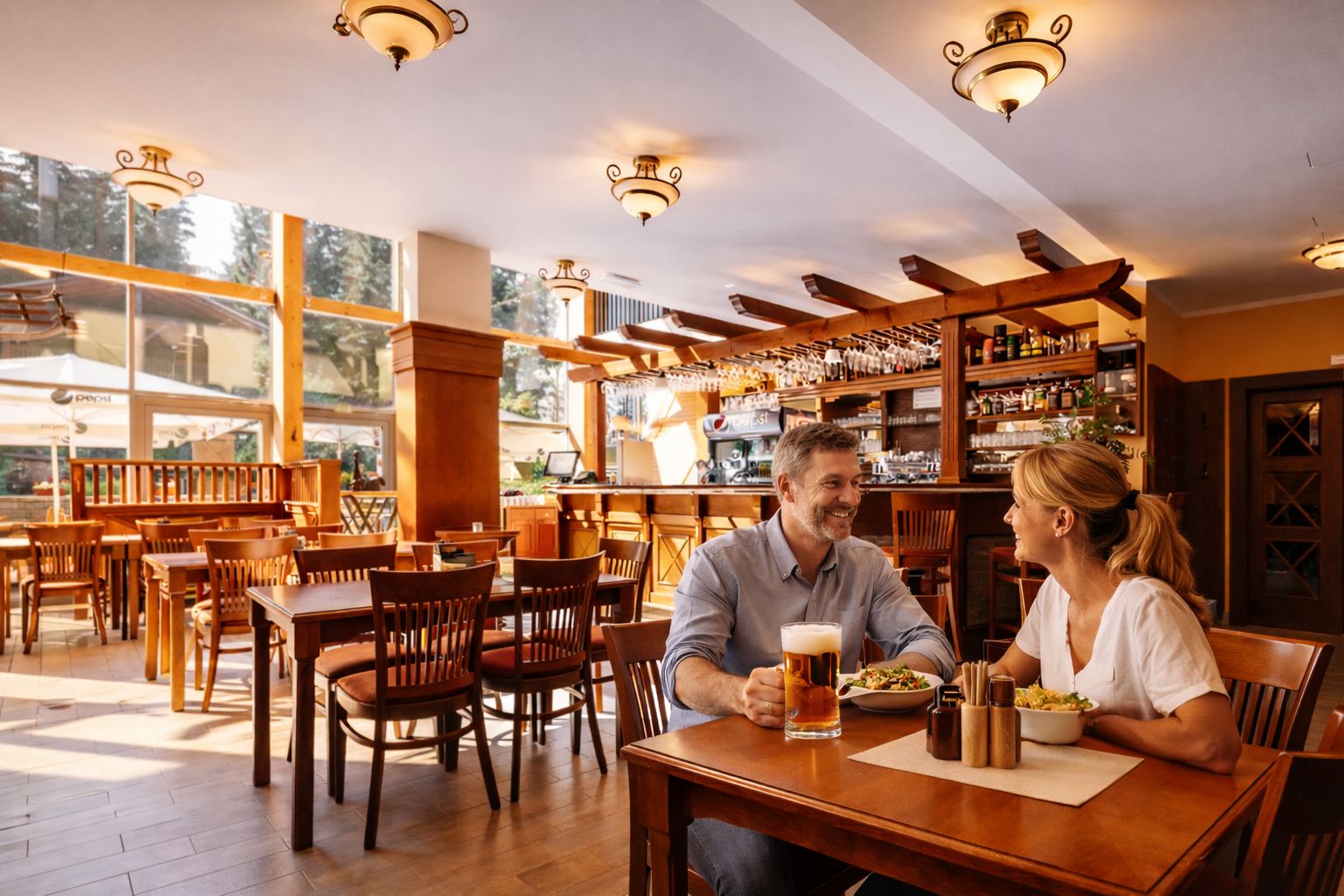 Un ristorante con arredamento in legno, un'area bar e ampie finestre che lasciano entrare la luce naturale.