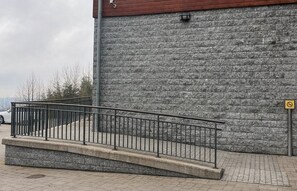 A stone wall with a metal railing in front. - Hotel Obří Sud (Dlouhý Most)