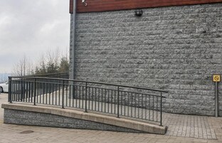 Un muro de piedra con barandilla de metal.