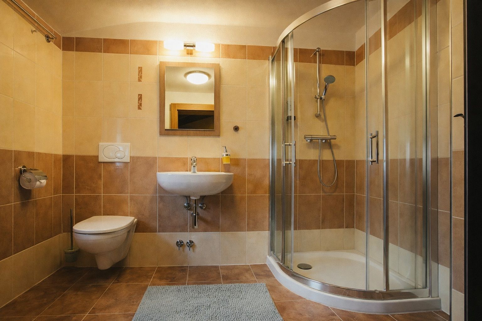 A modern bathroom with a toilet, sink, and glass-enclosed shower.