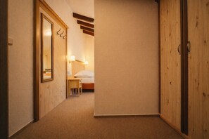 A hotel room with a bed, bedside table, lamp, and wardrobe. - Hotel Obří Sud (Dlouhý Most)