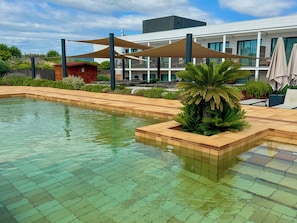 Una piscina al aire libre de temporada, sombrillas