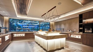Una cocina moderna con una isla central, ventanas amplias y un suelo con diseño en espiga.
