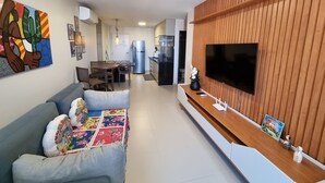 Una sala moderna con un sofá, televisor y una pared de acento de madera.