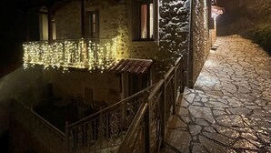 A stone house with a balcony at night, illuminated by string lights. - Dandy Villas Dimitsana a family home in a quaint historic neighborhood  (Dimitsana)