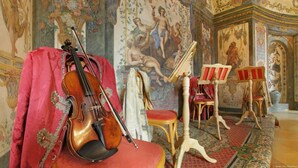 Une pièce contenant un violon, des chaises et un pupitre à musique.