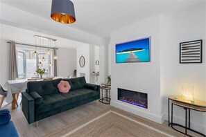 Smart TV, chimenea, libros y bocina smart 