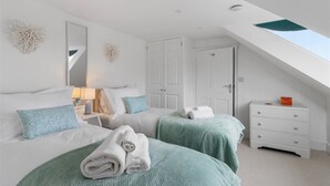 A bedroom with two beds, a nightstand, a dresser, and a skylight. - 4 Bedroom Seaside House, Beach 220m with Free Parking (Sidmouth)