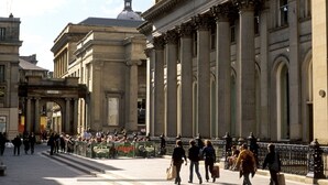 Ein historisches Gebäude mit klassischer Architektur, darunter Säulen und Bögen.