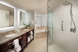 Ein modernes Badezimmer mit zwei Waschbecken, einer Duschkabine aus Glas und einem großen Spiegel.