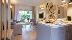 A modern kitchen with a central island, a dining area with a sofa and chairs, and a large window with curtains. - Renovated apartment Brise Marine II near the beach and close to St-Tropez (Gassin)