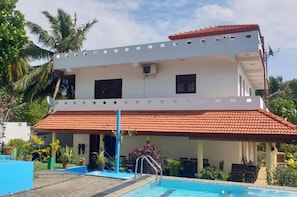 A two-story building with a swimming pool, a covered patio, and a red-tiled roof. - Tropical Paradise Villa in Talpe (Unawatuna)