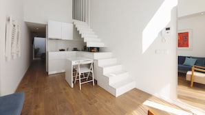 A modern interior with a staircase, a kitchen area, and a seating area. - RIBEIRA FLORES 59 Downtown Apartments (Porto)