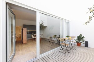 A modern interior with a sliding glass door leading to a wooden deck area.