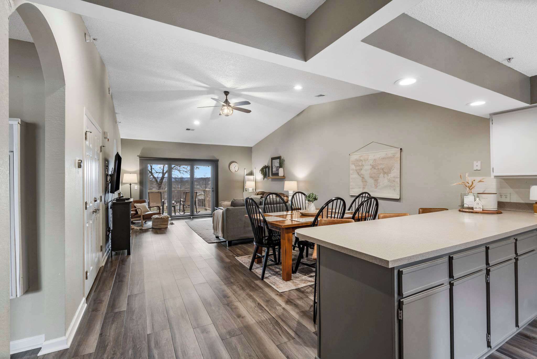 A spacious kitchen with a large island, dark wood flooring, and modern cabinetry.