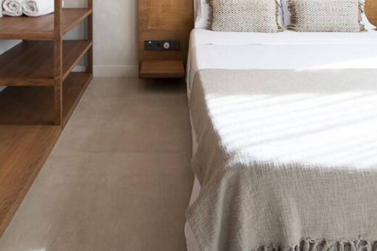 A bedroom with a bed, wooden shelves, and a nightstand.