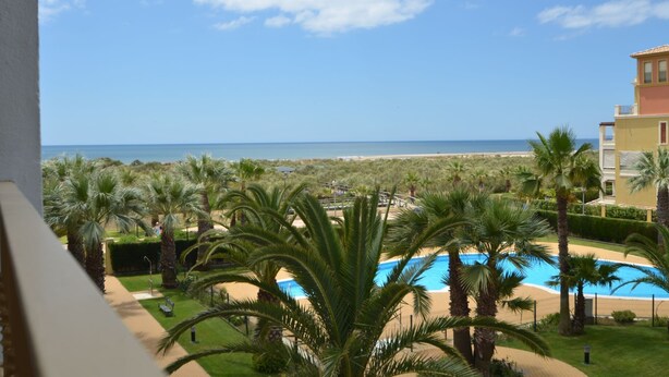 A resort with a swimming pool, palm trees, and a view of the beach and ocean. - LAS DUNAS 51 - Three Bedroom Apartment, Sleeps 7 (Punta del moral)