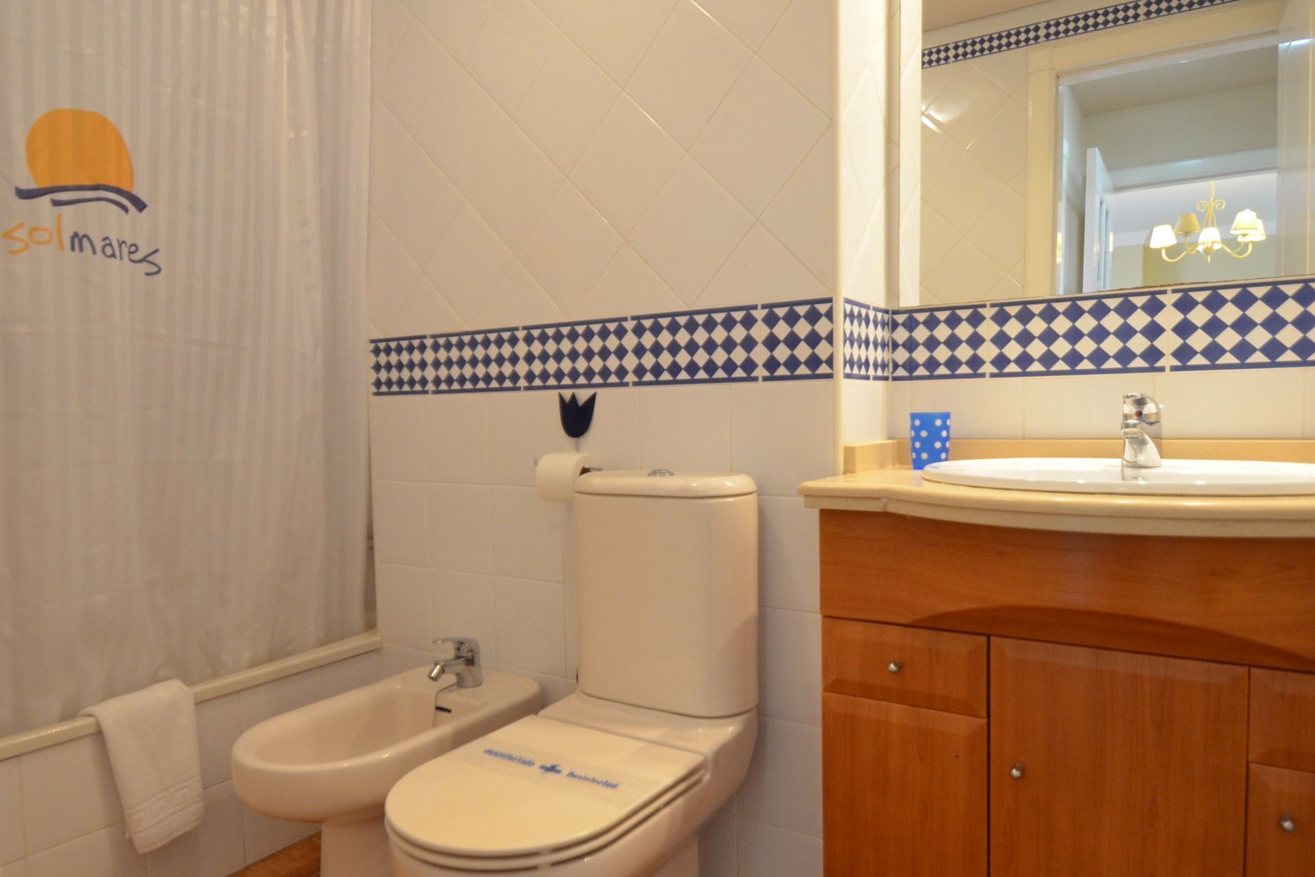 Un baño con inodoro, bidé y lavamanos.