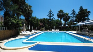 Una piscina al aire libre de temporada, sombrillas