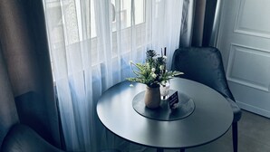 Una mesa redonda con dos sillas, una planta en maceta y un letrero que indica la disponibilidad de Wi-Fi.