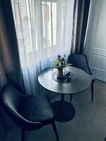 Un tavolo rotondo con due sedie, una pianta in vaso e un cartello che indica la disponibilità di Wi-Fi.