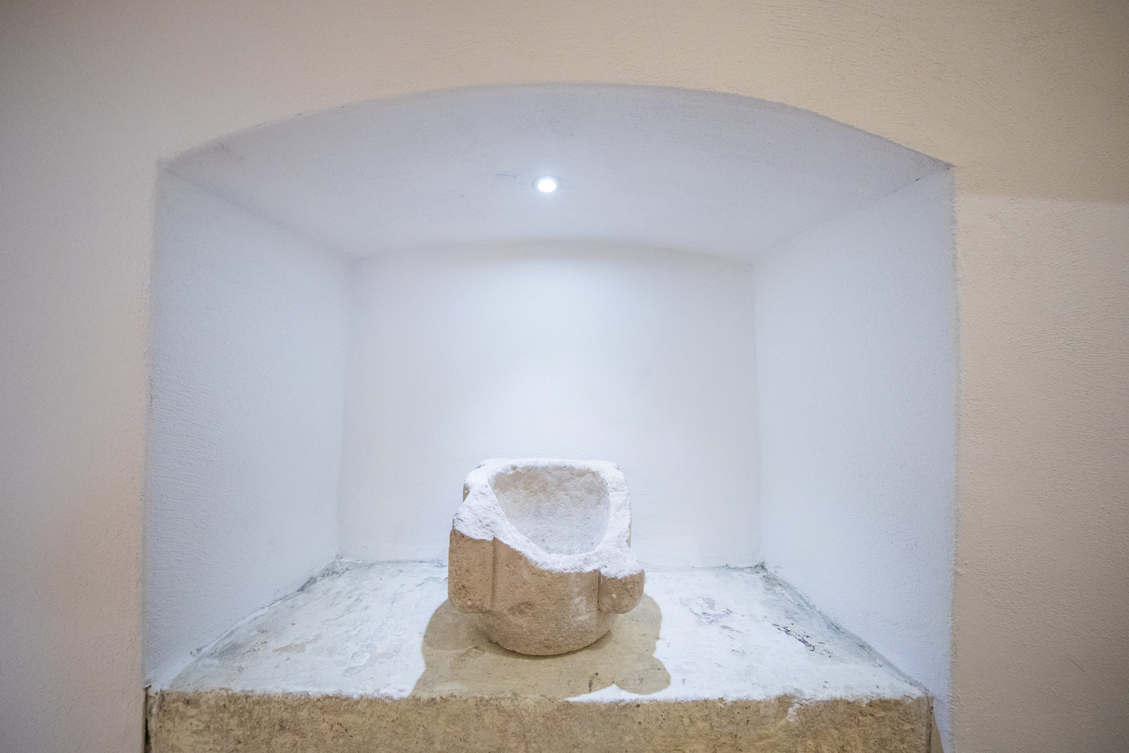 A stone sculpture in a white alcove with a recessed ceiling.