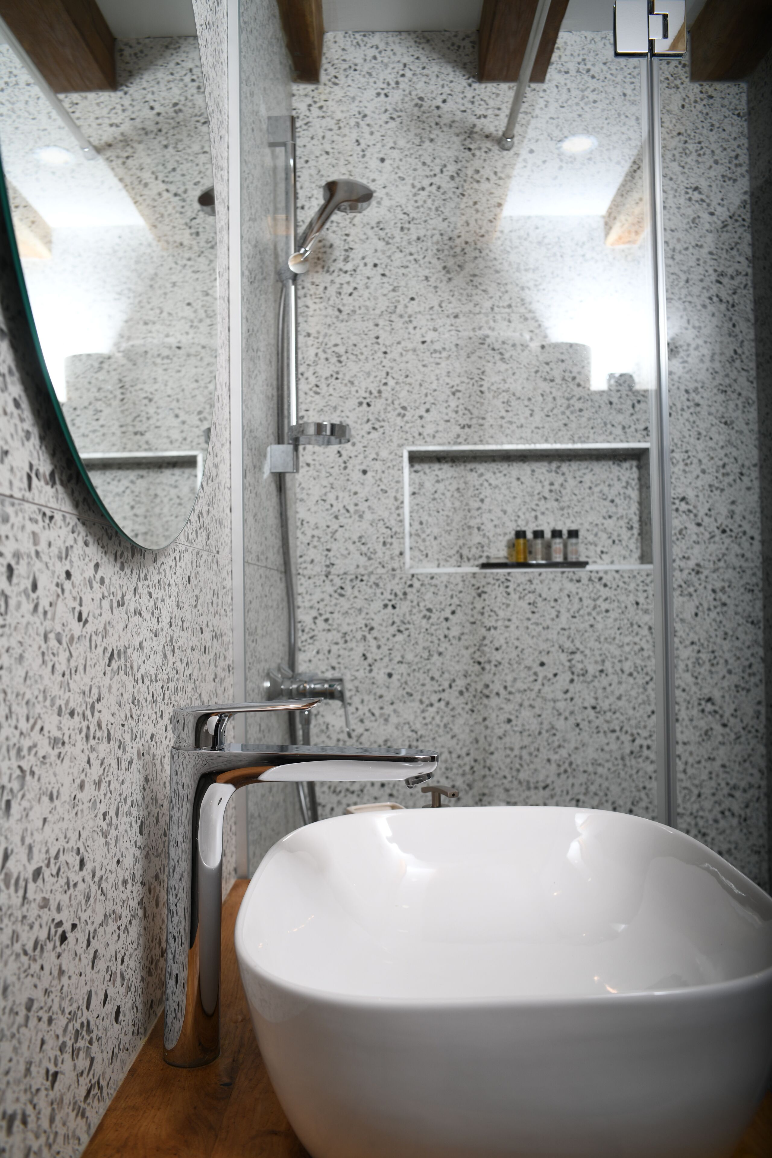 Un baño con un lavamanos blanco, un espejo y una ducha.