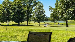 A view of a golf course with trees, a pond, and a golf cart. - Golf View Escape - Holiday Hills Branson - Golf - Outdoor Pools (Branson)
