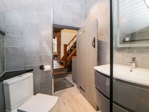 A modern bathroom with a toilet, sink, and shower area. - Eventide (Plymouth)
