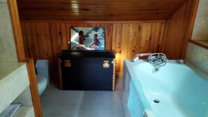 A wooden cabin bathroom with a bathtub, a small trash bin, and a wooden cabinet. - Your Nomadic Room : Outremer (Marthod)