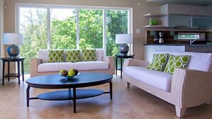 A modern living room with a sofa, coffee table, and lamps. - 501 Ocean front condo at Ocean One Maxwell coast road Barbados (Oistins)