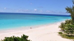 A beach with clear turquoise water, a sandy shore, and some greenery. - 501 Ocean front condo at Ocean One Maxwell coast road Barbados (Oistins)