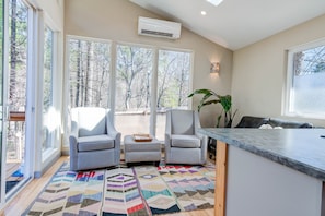 Relax in a serene space with a seating area, large window, and kitchen counter.