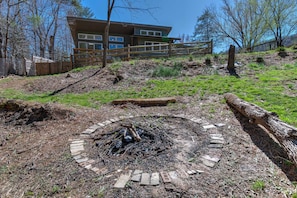 Surrounded by nature, this serene setting features a cozy fire pit and a tranquil atmosphere.