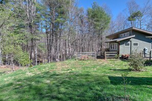 Escape to a serene retreat surrounded by tall trees and a well-manicured lawn.