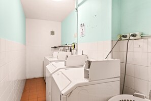 A public restroom with multiple washing machines, a toilet, and a hand dryer. - Chic Studio with a Pool and Moments from Shop (Bondi Junction)