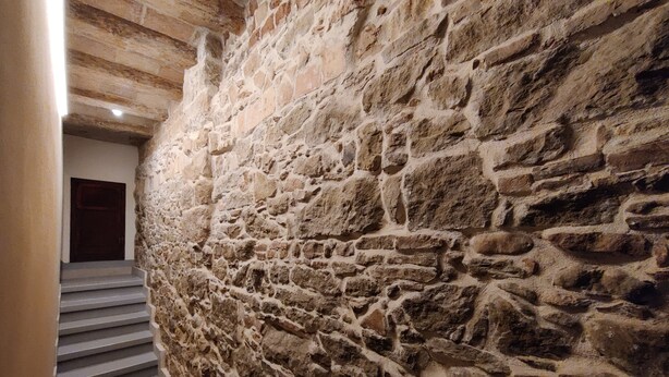 A stone wall with a staircase leading to a door. - Charming Loft in the Historic Center of Manresa. (Manresa)